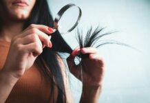 변화하는 헤어 건강 트렌드… 집에서 실천하는 두피 케어 루틴이 인기 Woman examining split ends of hair with magnifying glass