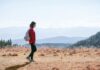 자연 걷기 열풍, 건강한 삶을 위한 실천법 제시 a man with a backpack walking across a dry grass covered field